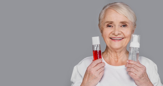 Close-up woman holding serum bottles