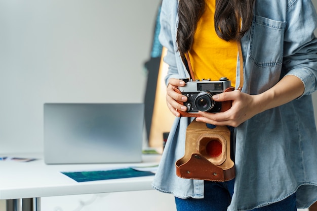 Free photo close-up woman holding small camera