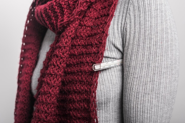 Free Photo close-up of woman holding thermometer under her arm