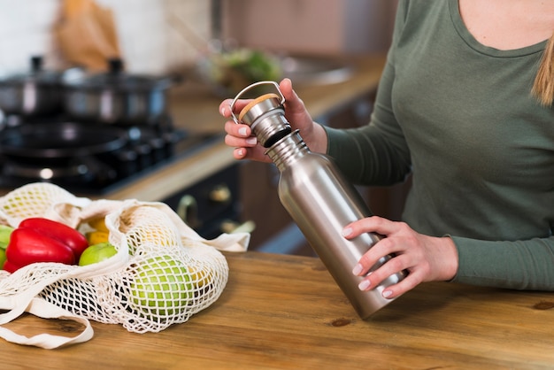 Free photo close-up woman holding thermos bottle