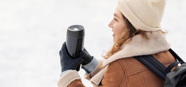 Free photo close-up woman holding thermos