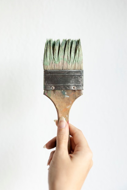 Free photo close-up woman holding up a brush