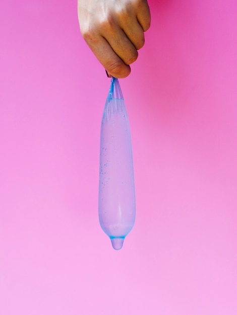 Free photo close-up woman holding up a filled condom