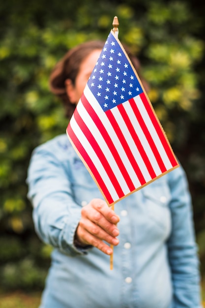 Free photo close-up of a woman holding usa american flag in front of her face