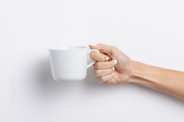 Close-up woman holding white empty cup