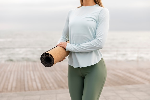 Free photo close up woman holding yoga mat