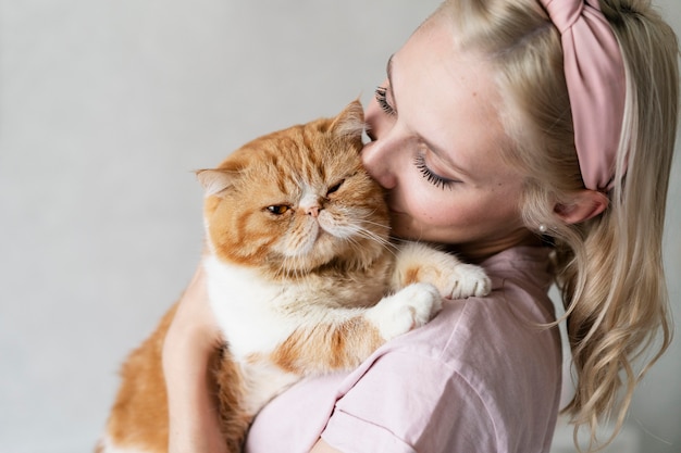 Free Photo close up woman kissing cat