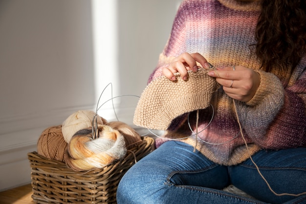 Free Photo close up woman knitting on floor