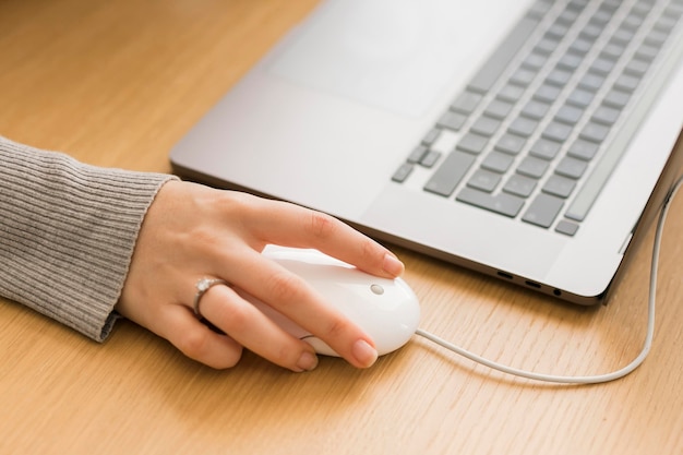 Close-up woman on laptop using mouse