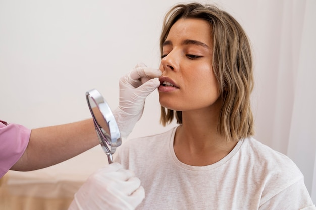 Close up woman looking in the mirror after lip filler