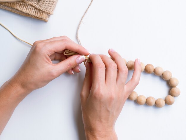 Close-up of woman making wood beads accessories