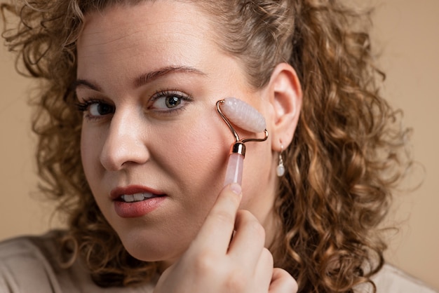 Close up woman massaging face with gua sha