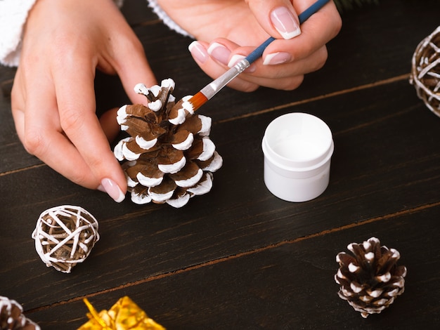 Free photo close-up of woman painting pine cones