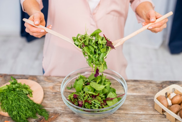 Free photo close-up of woman preparing the leafy vegetable salad