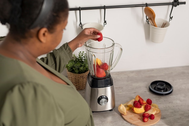 Free photo close up woman preparing smoothie