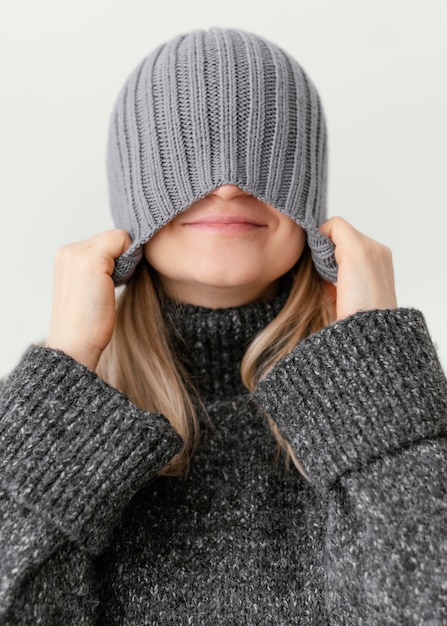 Free photo close-up woman pulling down hat