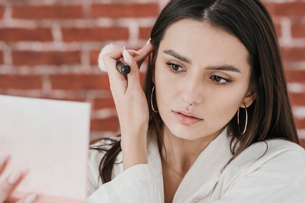 Free Photo close-up woman putting on make-up