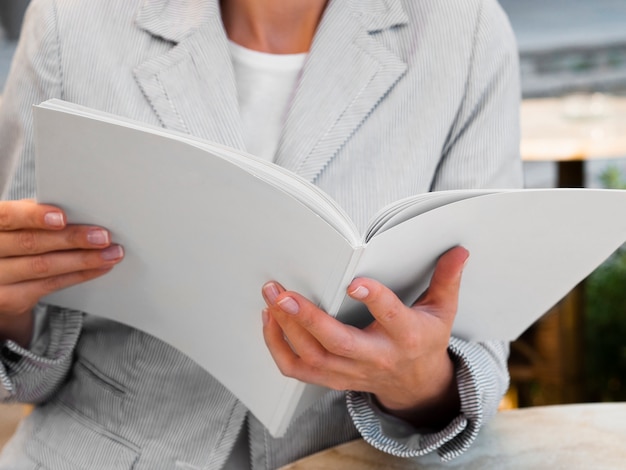 Free photo close-up woman reading a mock-up magazine