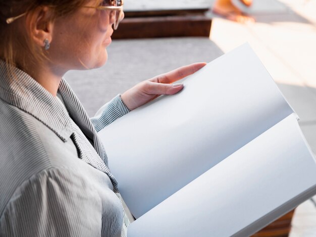 Close-up woman reading a mock-up magazine