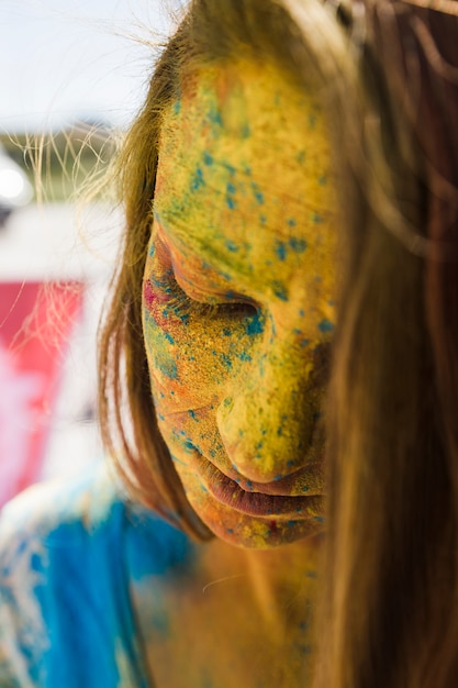 Free photo close-up of woman's face covered with yellow holi color