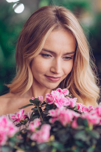 Close-up of woman's face looking at pink flowers