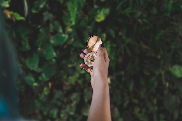 Free Photo close-up of woman's hand holding golden retro compass