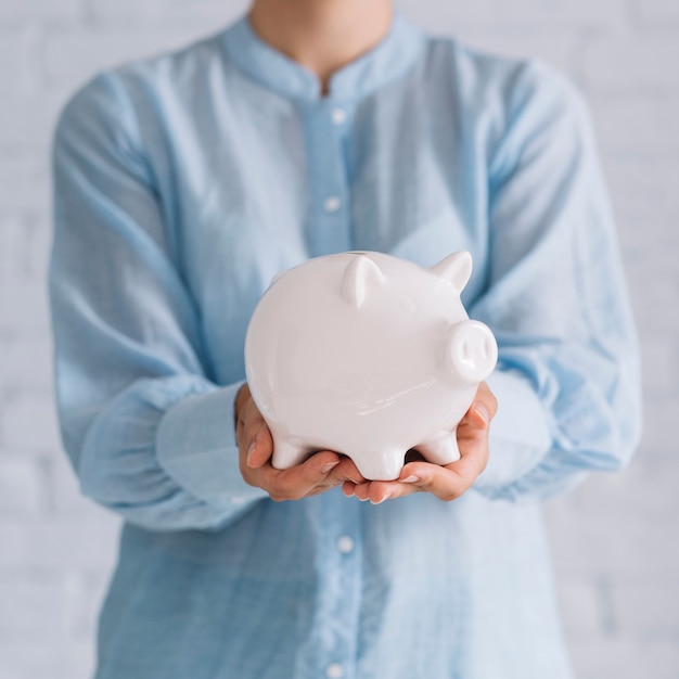 Free photo close-up of a woman's hand holding piggybank