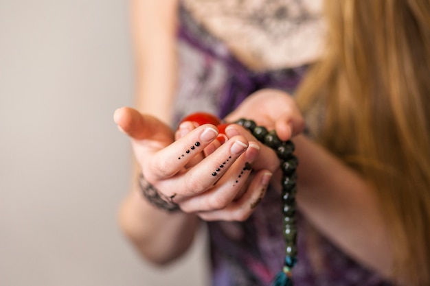 Free photo close-up of woman's hand holding red chinese balls and spiritual beads