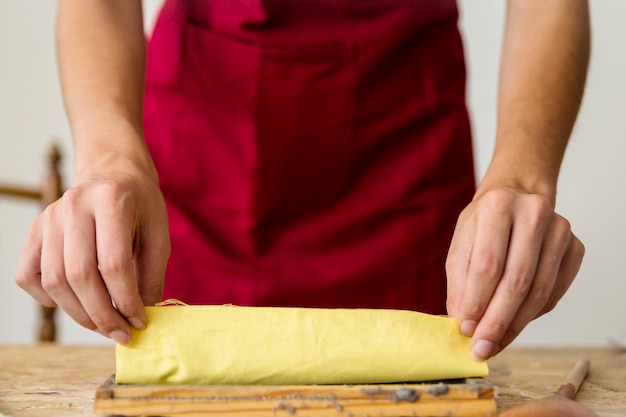 Free photo close-up of a woman's hand placing yellow cloth on paper pulp