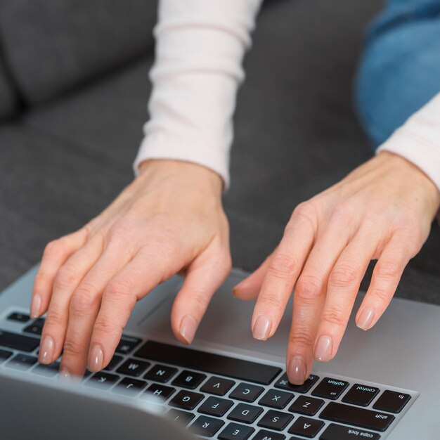 Close-up of woman's hand typing on laptop