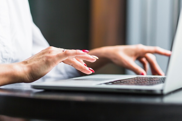 Free photo close-up of a woman's hand using laptop