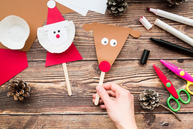 Close-up of woman's handholding props made with paper on wooden desk