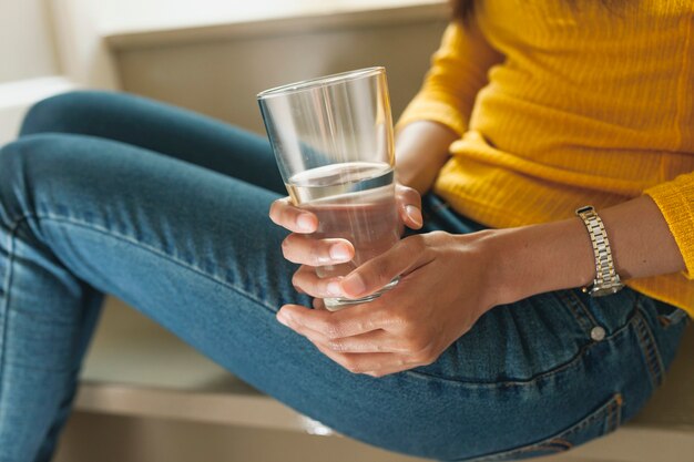 Close-up of woman's hands with water glass