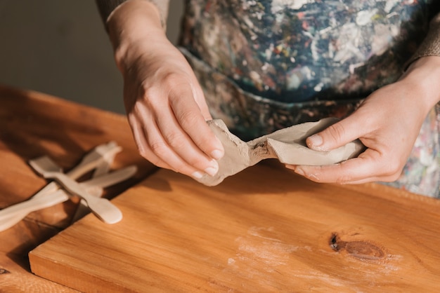 Free Photo close-up of woman shaping clay