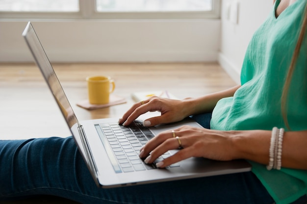 Close-up woman sitting on floor and working