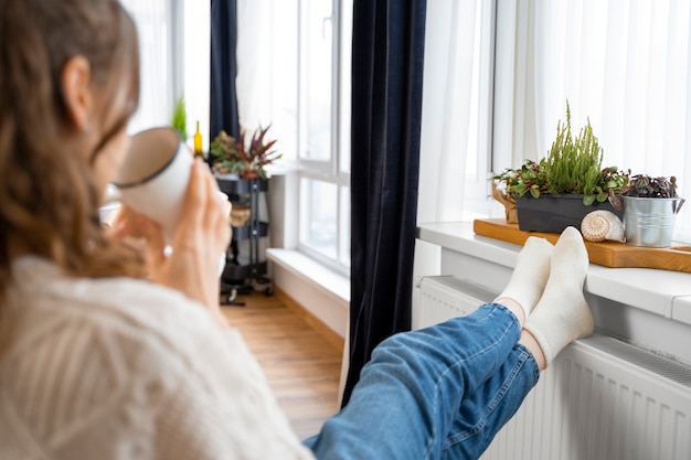 Free photo close up woman sitting near heater