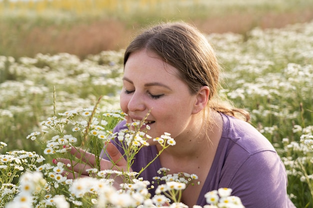 Free photo close up woman smelling flowers