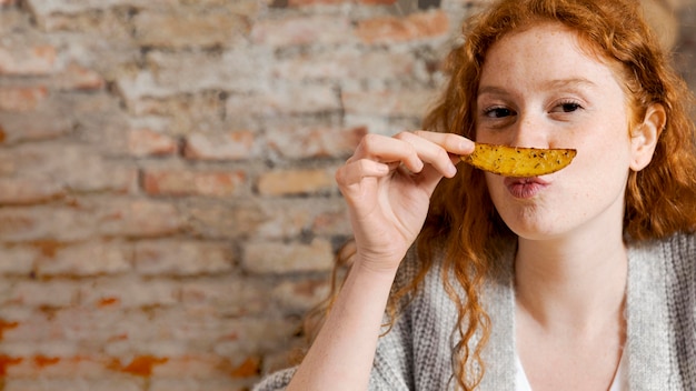 Close up woman smelling potato