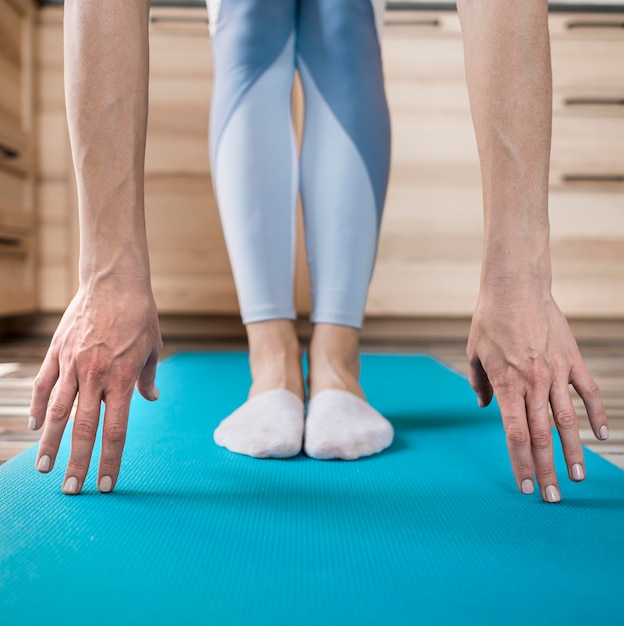 Close-up woman stretching on yoga mat