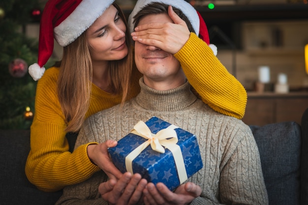 Close up woman surprising man with gift