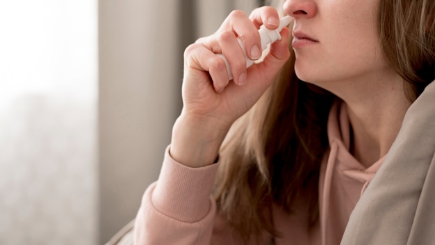 Close-up woman taking treatment for runny nose