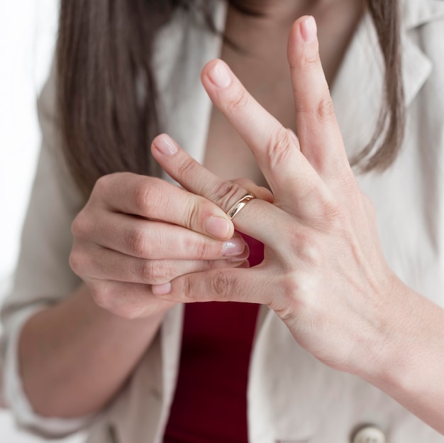 Close-up woman taking wedding ring off finger