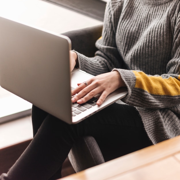 Free photo close up of woman typing on laptop in coffee shop