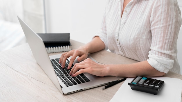 Close-up woman typing on laptop