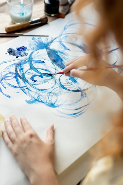 Close-up woman using blue paint