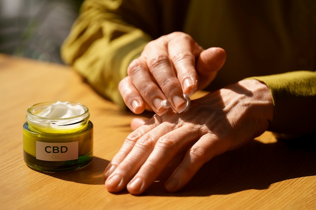 Close up on woman using cbd cream for pain