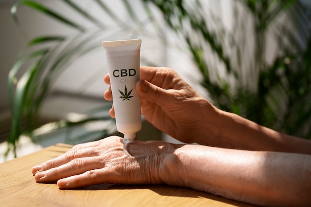 Free Photo close up woman using cbd cream