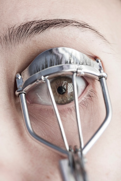 Free photo close-up of woman using an eyelash curler