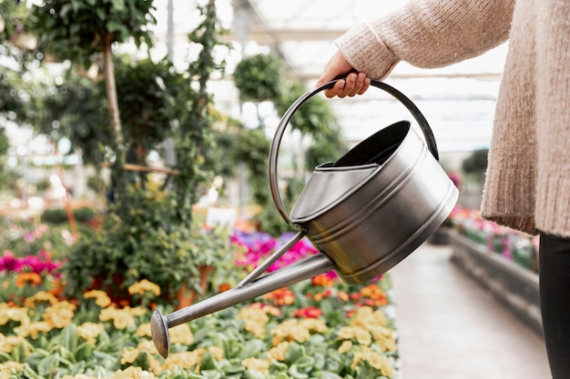 Close-up woman watering the flowers