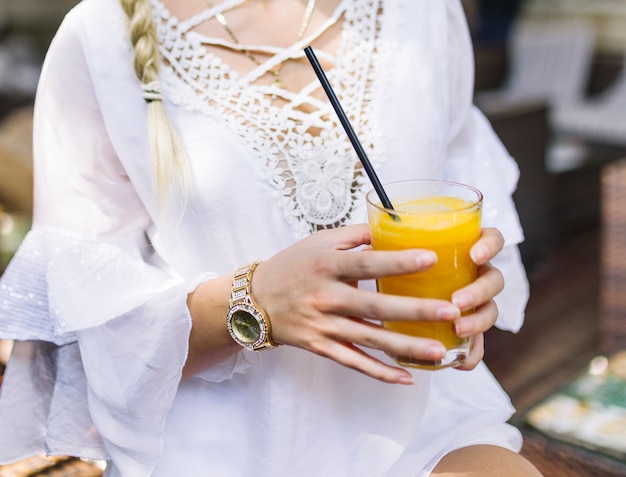 Free Photo close-up of a woman in white dress holding glass of healthy juice